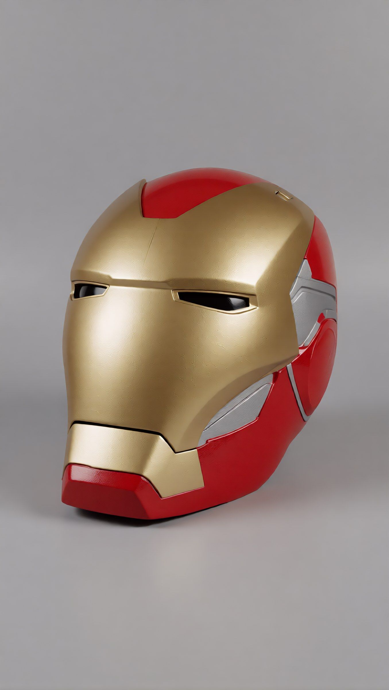 The finished red and gold Iron Man helmet photographed on a plain grey background
